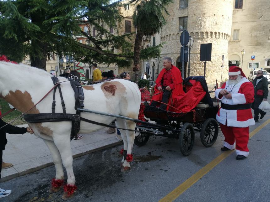 Simpatici Babbi Natale in carrozza e in Vespa, tanti bambini in sella: la festa in centro
