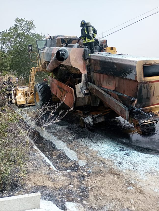 Vigili del fuoco all'opera sulla trebbiatrice in fiamme