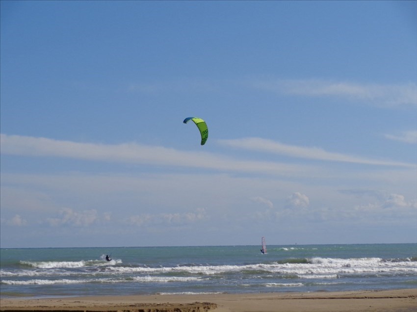 ​Gli amanti del surf e del kite sfidano vento e onde in una danza ipnotica