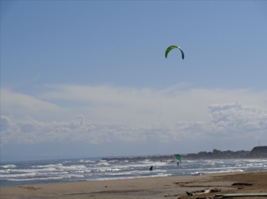 ​Gli amanti del surf e del kite sfidano vento e onde in una danza ipnotica